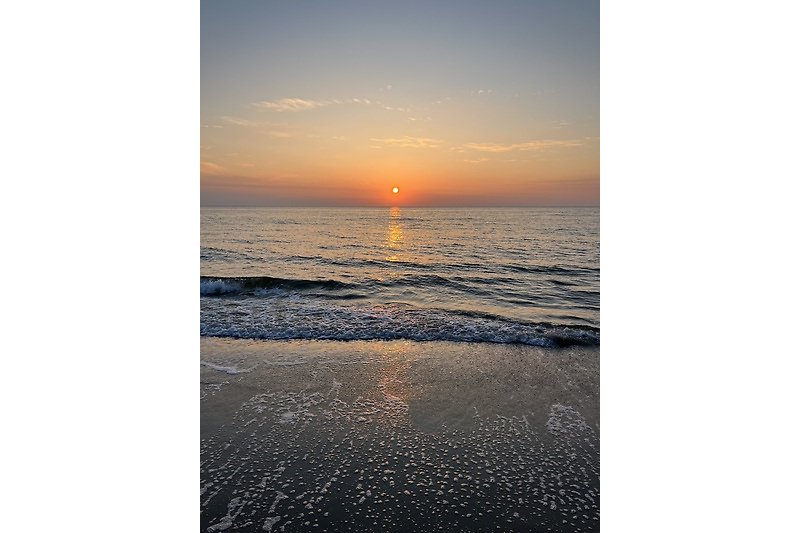 Genießen Sie den Blick auf den Ozean und wunderschön Sonnenuntergänge am Strand.