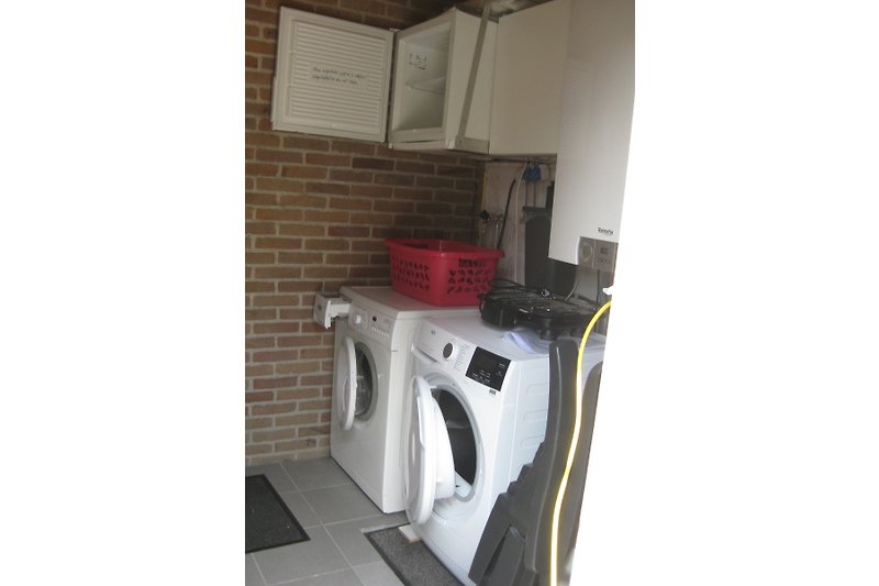 Externer Abstellraum über die Terrasse zugänglich mit Waschmaschine, Wäschetrockner und Gefrierschrank.