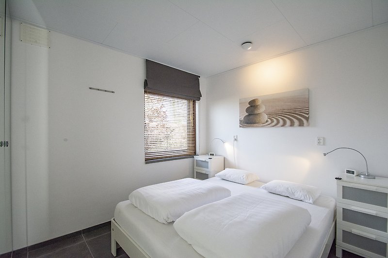 Genießen Sie den Komfort und das stilvolle Design dieses Schlafzimmers mit gemütlicher Beleuchtung.
