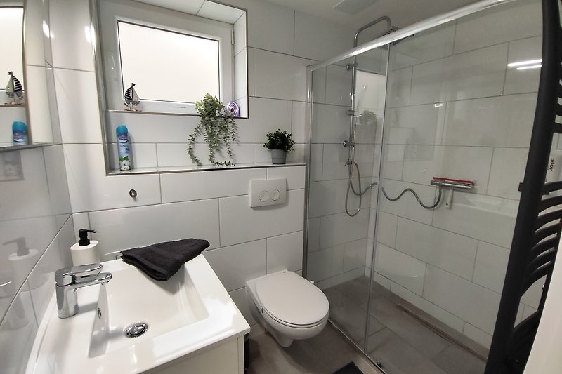 Entspannen Sie in diesem modernen Badezimmer mit lila Akzenten und genießen Sie die luxuriöse Ausstattung.