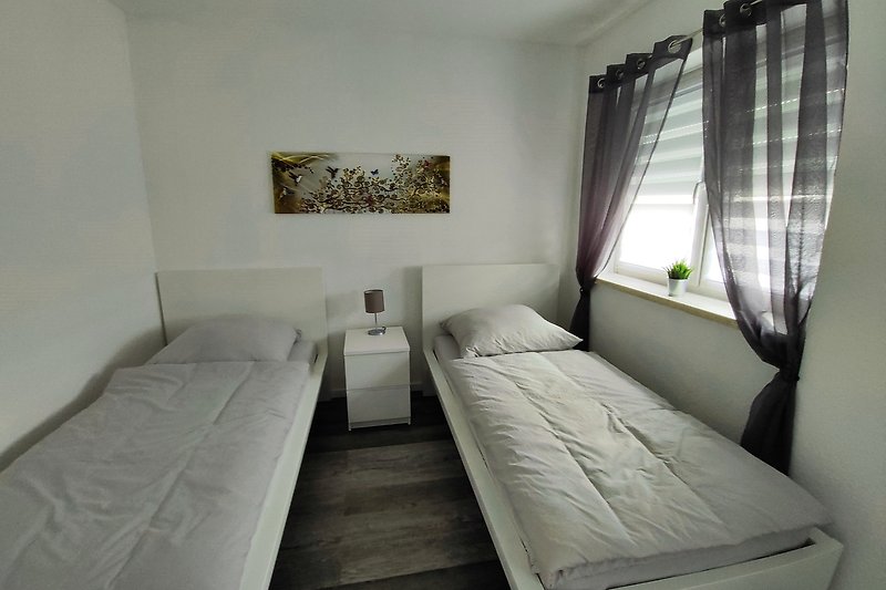 Entspannen Sie auf dem bequemen Bett mit Holzrahmen und genießen Sie den Komfort dieses Schlafzimmers. Schlafen Sie gut!