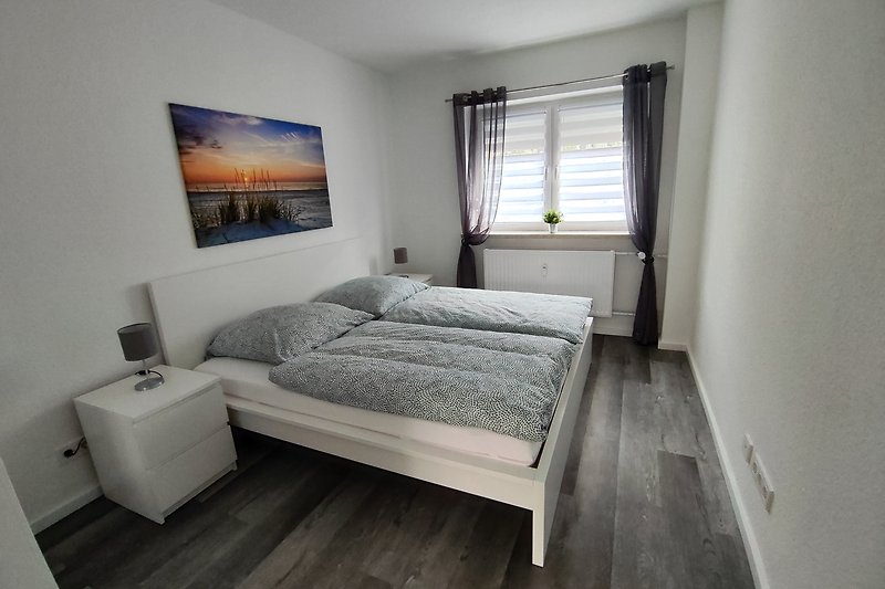 Genießen Sie den Komfort dieses modernen Schlafzimmers mit Holzbettgestell und Nachttisch. Entspannen Sie und schlafen Sie gut!