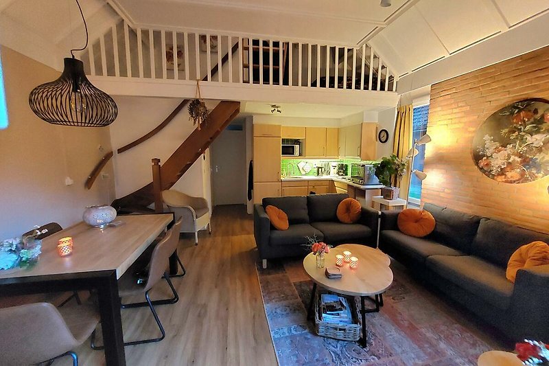 Gemütliches Wohnzimmer mit Holzmöbeln, bequemer Couch und stilvoller Beleuchtung.