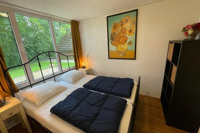 Schlafzimmer mit Doppelbett, Nachttischen und Stauraum für Kleidung