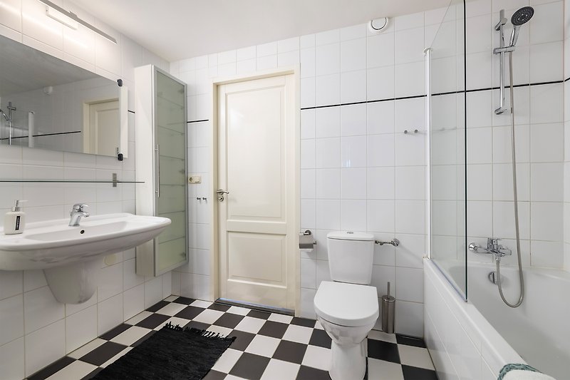 Prachtige paarse badkamer met spiegel, kraan en wastafel.