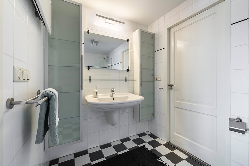 Prachtige paarse badkamer met spiegel, kraan en wastafel.