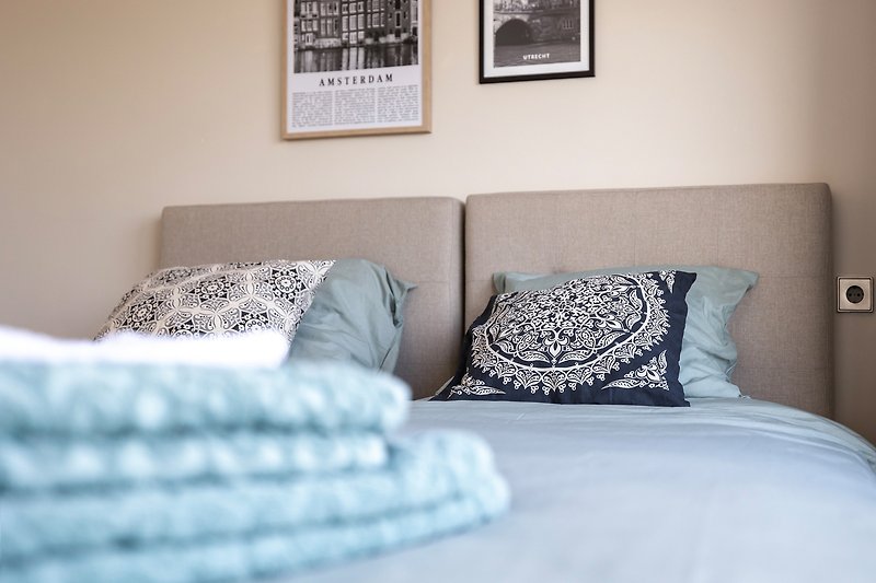 Comfortabele slaapkamer met stijlvolle verlichting en zachte kussens.