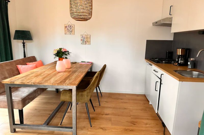 Mooie keuken met houten meubels, planten en een aanrechtblad.