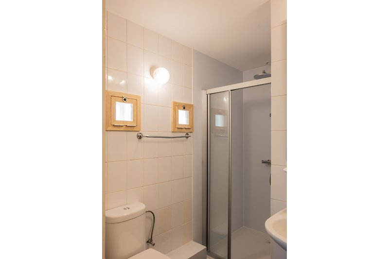 Schönes Badezimmer mit modernen Armaturen und Glasduschtür.