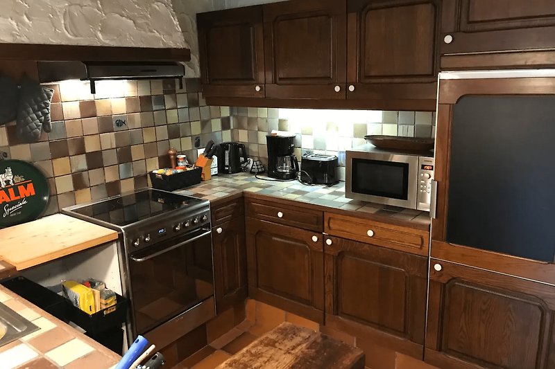 Gemütliche Küche mit braunen Holzschränken und Arbeitsplatte.