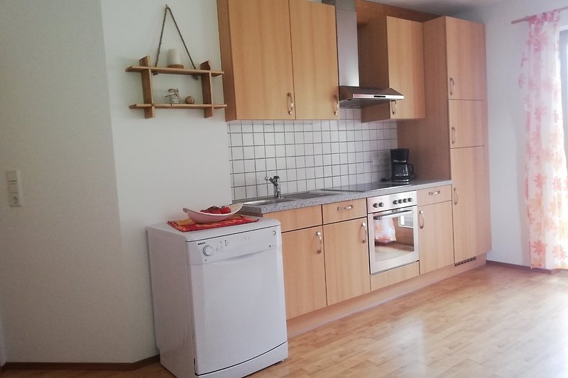 Moderne Küche mit braunen Schränken, Arbeitsplatte und Holzboden.