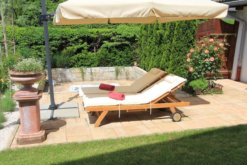 Genießen Sie die Sonne auf der Terrasse mit bequemen Gartenmöbeln.