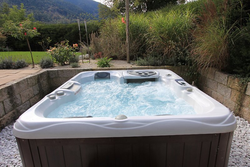 Entspannen Sie im luxuriösen Pool mit Jacuzzi und Blick auf die Landschaft.