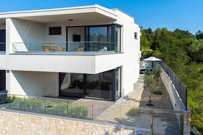 Moderna Villa Voco s prostranim terasama uz pogled na zelenilo, bazen i more u mirnoj četvrti Malinske.
