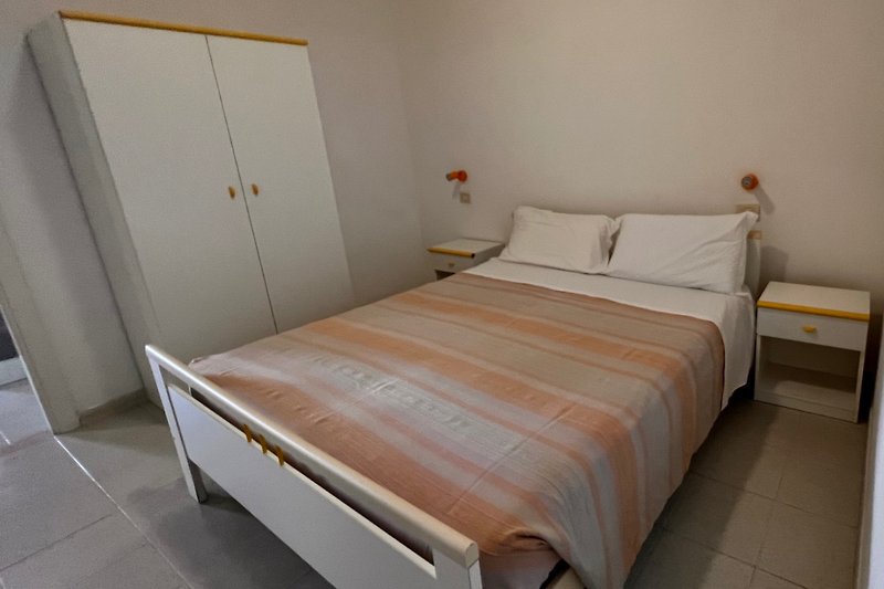 Una camera da letto con un comodo letto in legno e biancheria di alta qualità.