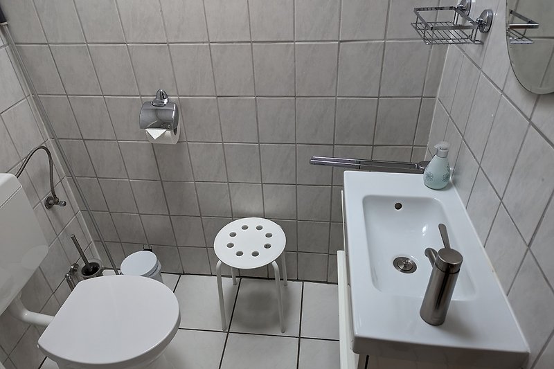 Schwarzes Badezimmer mit stilvollem Wasserhahn und Keramikwaschbecken.