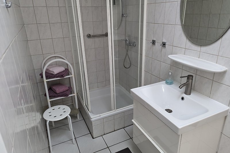 Schönes Badezimmer mit lila Waschbecken und Spiegel.
