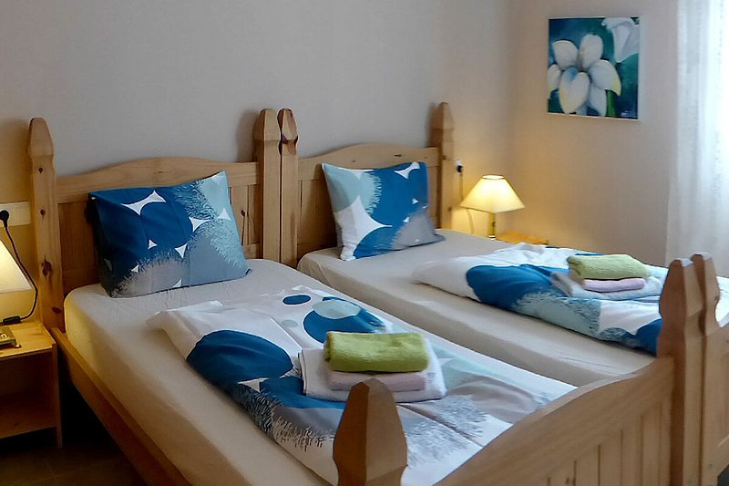 Comfortabele slaapkamer met houten bedframe en luxe beddengoed.