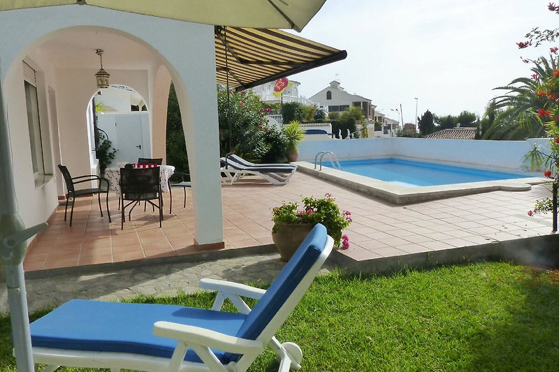 Prachtige villa met zwembad, tuin en buitenmeubilair in een rustige woonwijk.