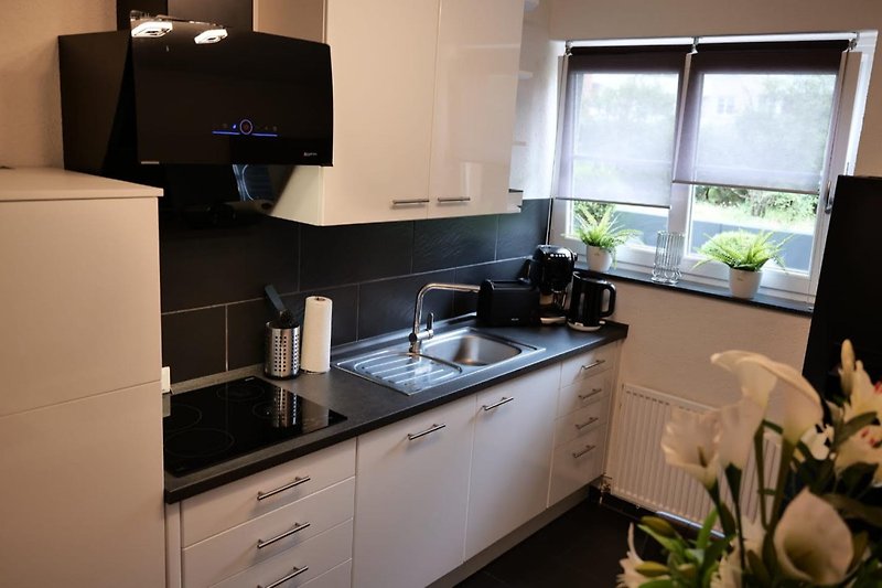 Moderne Küche mit stilvoller Einrichtung, Arbeitsplatte und Fensterblick.