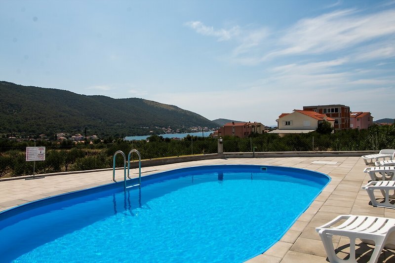 Schönes Ferienhaus mit Pool und Blick auf das azurblaue Wasser.