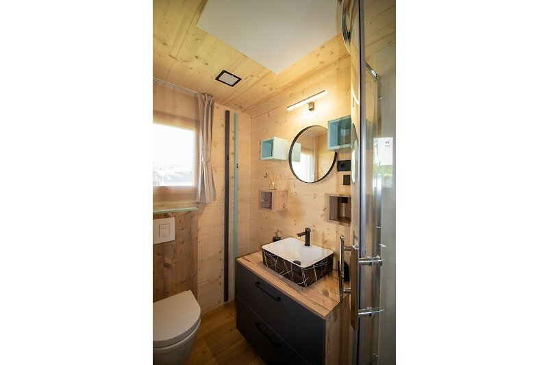 Schönes Badezimmer mit Spiegel, Waschbecken und Duschtür.
