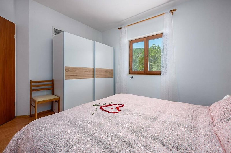 Prekrasna spavaća soba s udobnim krevetom i drvenim namještajem.