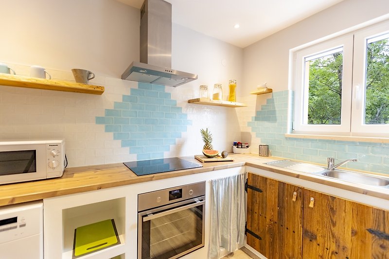Predivan interijer kuhinje s drvenim elementima i prozorom.