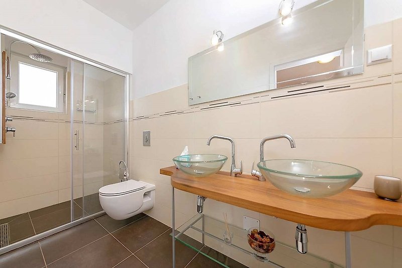 Predivna kupaonica s modernim umivaonikom i ogledalom.