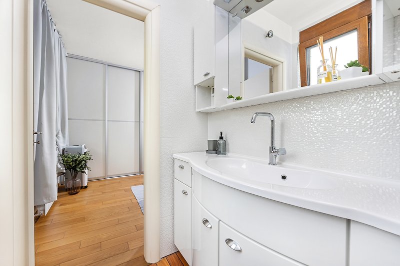 Prekrasna kupaonica s modernim namještajem i elegantnim umivaonikom.