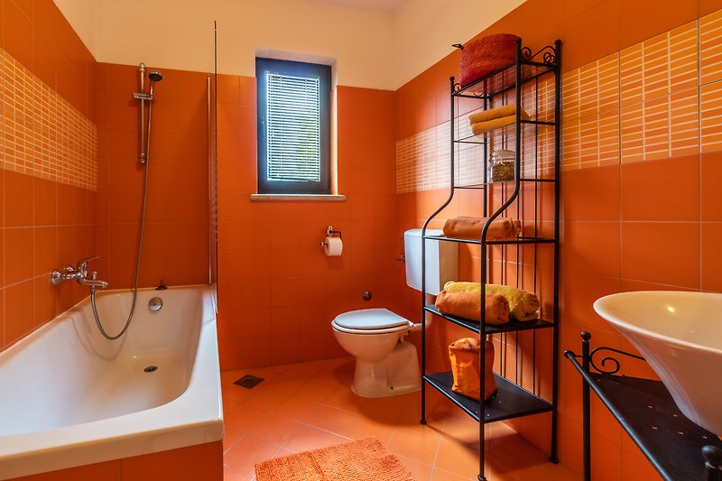Moderan kupaonski prostor s narančastim detaljima