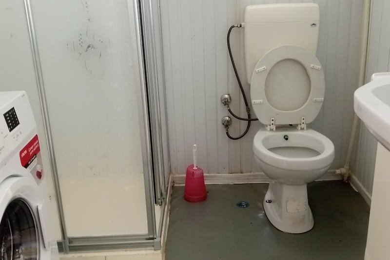 Gemütliches Badezimmer mit lila Toilette und Gasinstallation.