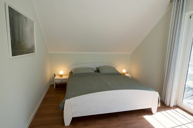 Stilvolles Schlafzimmer mit bequemem Bett und schöner Inneneinrichtung im Obergeschoss