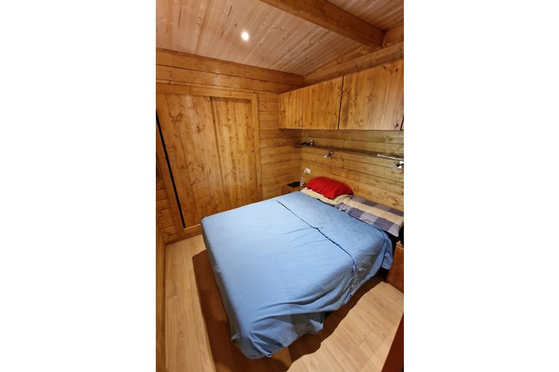 Accogliente camera da letto con arredamento in legno e biancheria da letto.