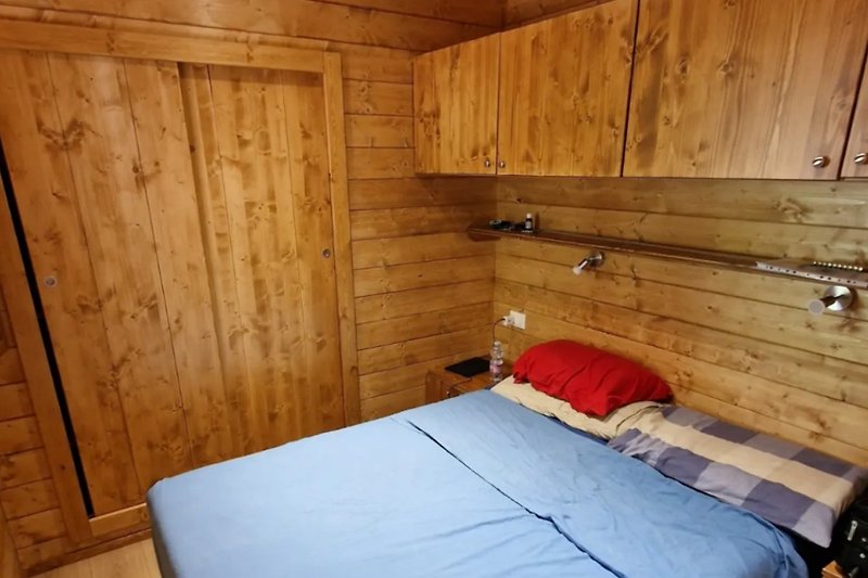 Una camera da letto accogliente con pavimento in legno e biancheria da letto.