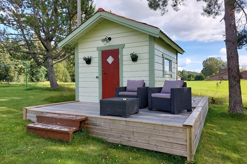 Vorderansicht der Stuga-Terrasse mit bequemen Möbeln und dem Eingang zu Ihrem Tiny House