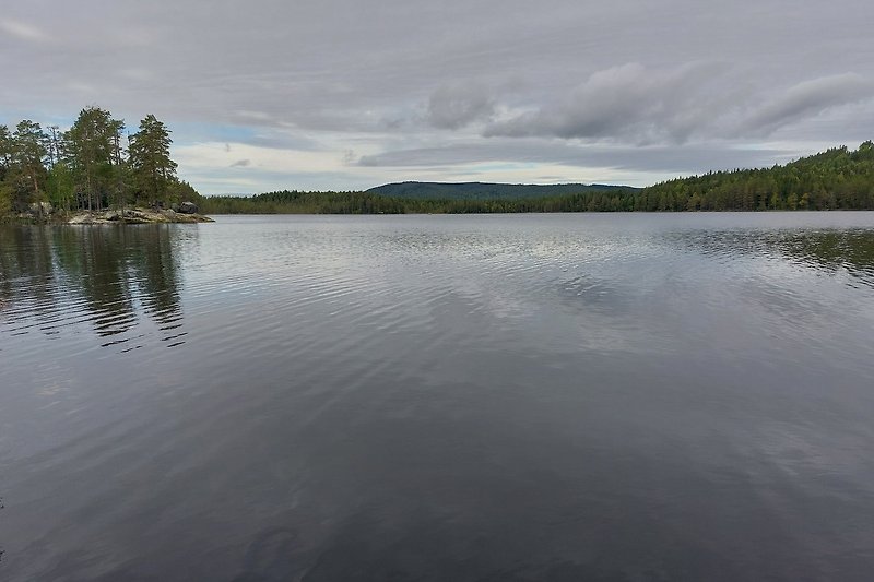 Kulltjärnen, ein schöner See, den man in 30 Minuten zu Fuß erreichen kann, liegt direkt hinter unserem Garten im Wald.
