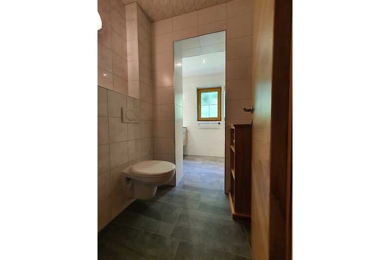Schönes Badezimmer mit Holzboden, Toilette und Waschbecken.