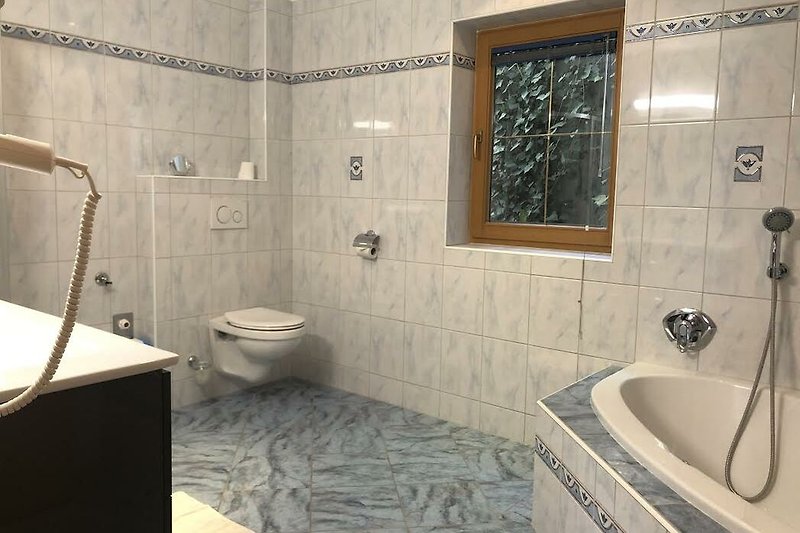 Schwarzes Badezimmer mit lila Akzenten, Badewanne und Dusche.