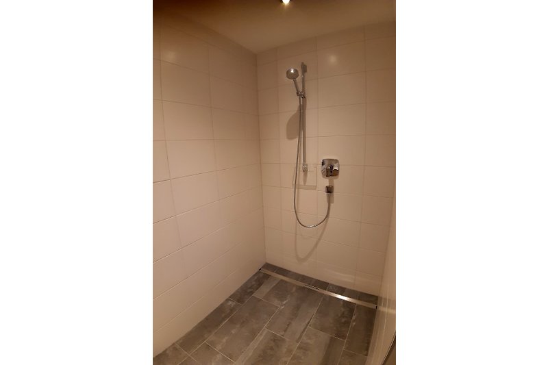 Schönes Badezimmer mit Fliesenboden, Toilette und Sanitärinstallationen.
