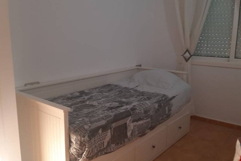 Cómoda habitación con cama de madera y ropa de cama.