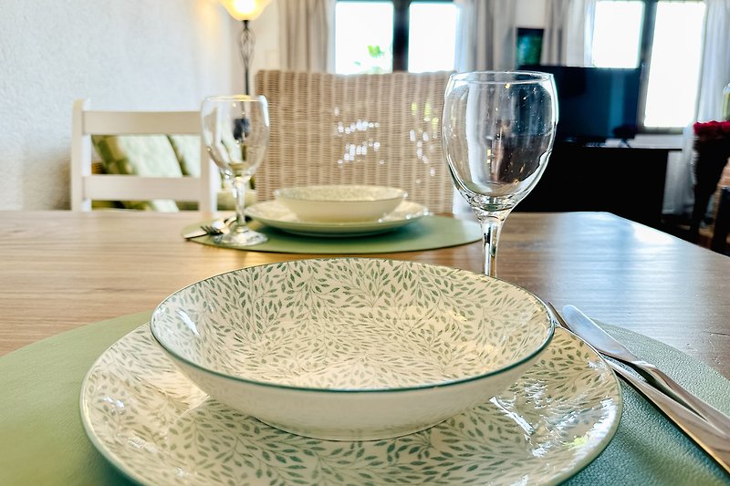 Eleganter Esstisch mit Porzellangeschirr und Besteck.