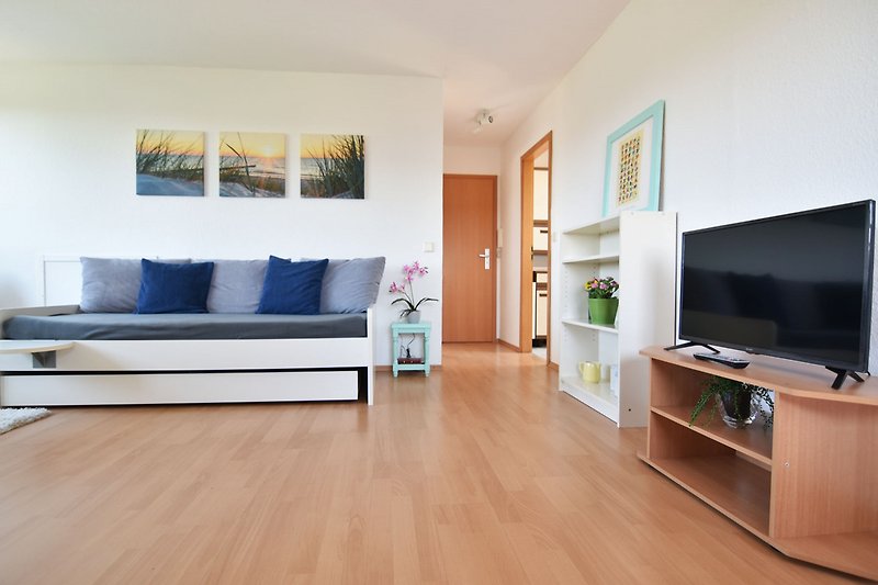 Moderne Wohnung mit stilvollem Interieur, bequemer Couch und Fernseher.
