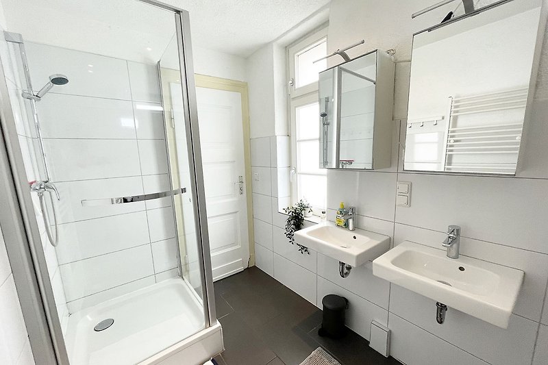 Schönes Badezimmer mit moderner Sanitäranlage und Spiegel.