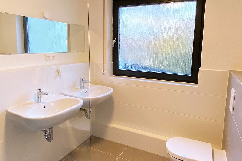 Schönes Badezimmer mit blauem Spiegel und lila Waschbecken.