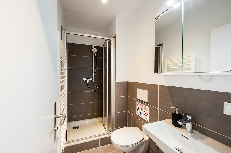 Schönes Badezimmer mit Spiegel, Waschbecken und Holztür.