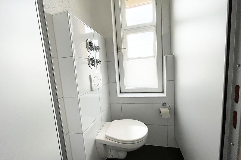 Gemütliches Badezimmer mit Holzboden und modernen Sanitäranlagen.