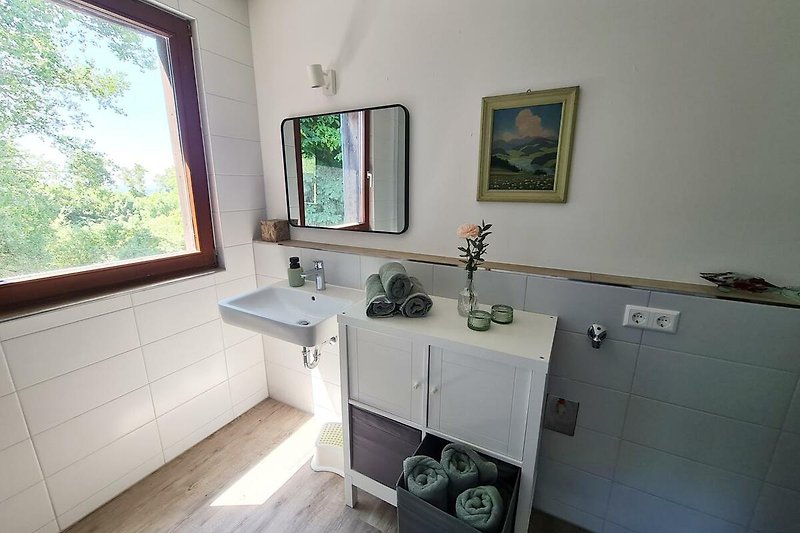 Schönes Badezimmer mit lila Wand, Holzboden und Armatur.
