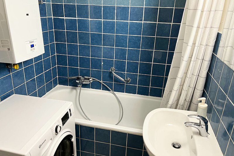 Schönes Badezimmer mit lila und blauen Fliesen und modernem Waschbecken.