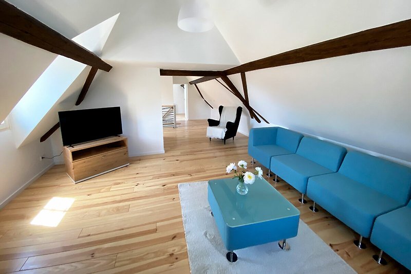 Schönes Wohnzimmer mit stilvollen Möbeln und Holzwänden.